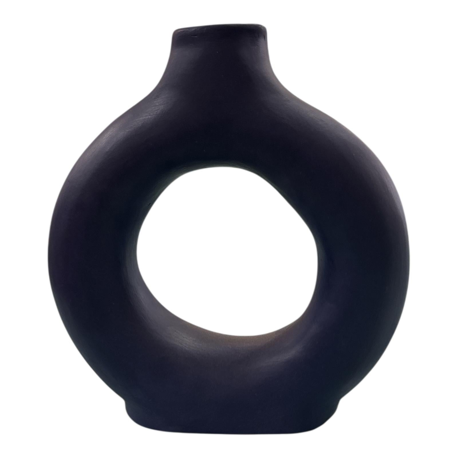 Vaso decorativo blu notte in ceramica con design a foro centrale, visto frontalmente.