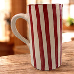 Vaso artigianale in ceramica a righe rosse e terracotta con un manico, fatto a mano, stile caldo e decorativo