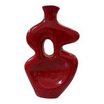 Vaso scultoreo in ceramica rosso con apertura centrale visto frontalmente
