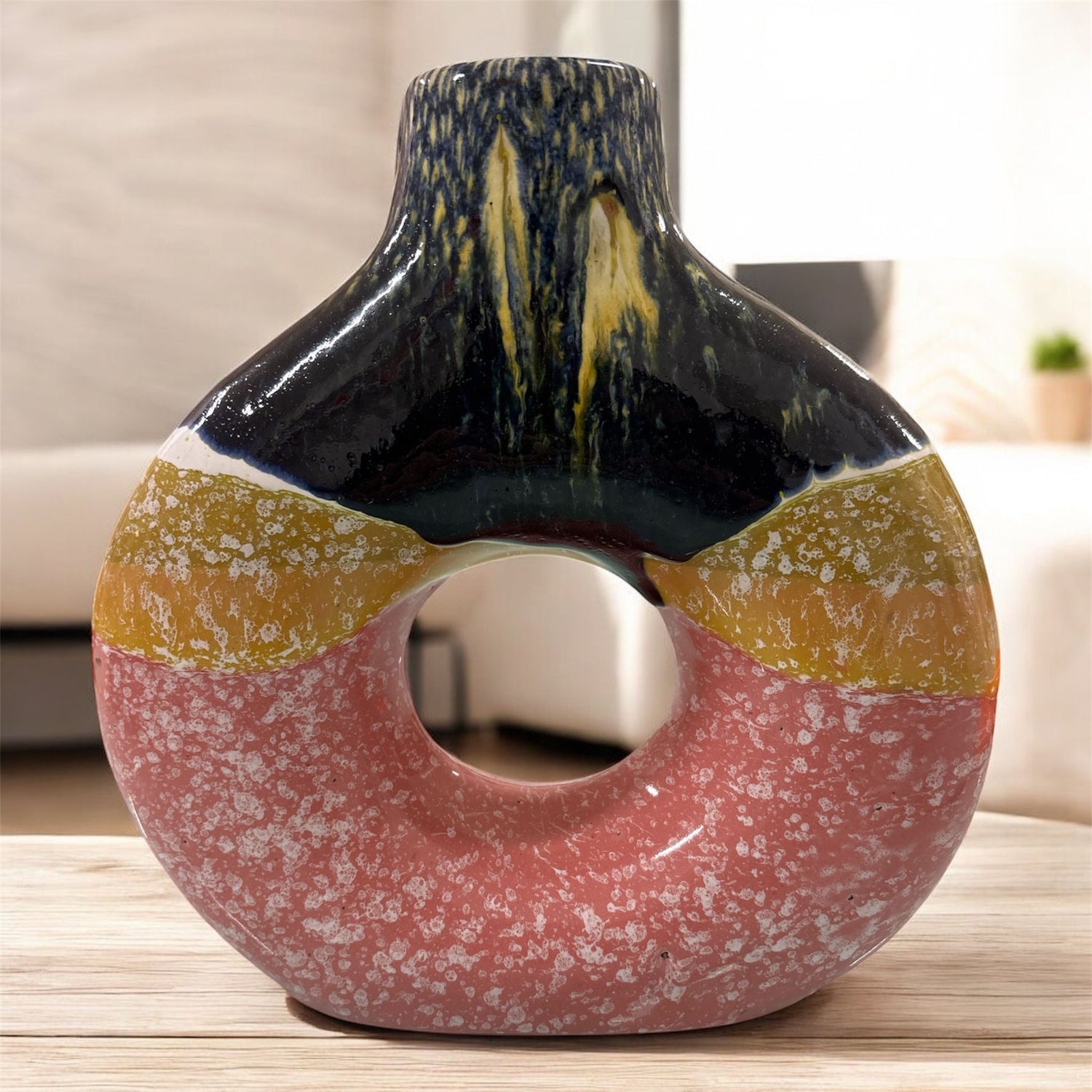 Vaso in ceramica tricolore con apertura centrale, fotografato in ambiente moderno